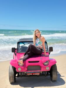 Buggy tout-terrain arrêté au sommet d'une dune rouge face au coucher du soleil à Canoa Quebrada