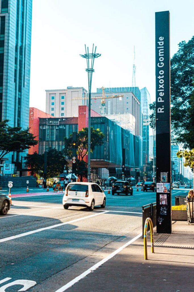 Morning street scene on R. Peixoto Gomide in São Paulo with cars and modern buildings.