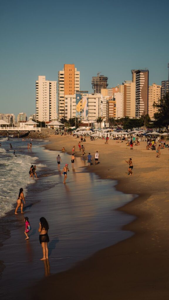 pexels-photo-39049825-39049825 Vibrant beach scene with Fortaleza's city skyline and beachgoers enjoying the sun in Ceará, Brazil.