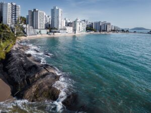 Aerial view of the beautiful Guarapari beachfront, showcasing urban skyline and tranquil blue ocean.