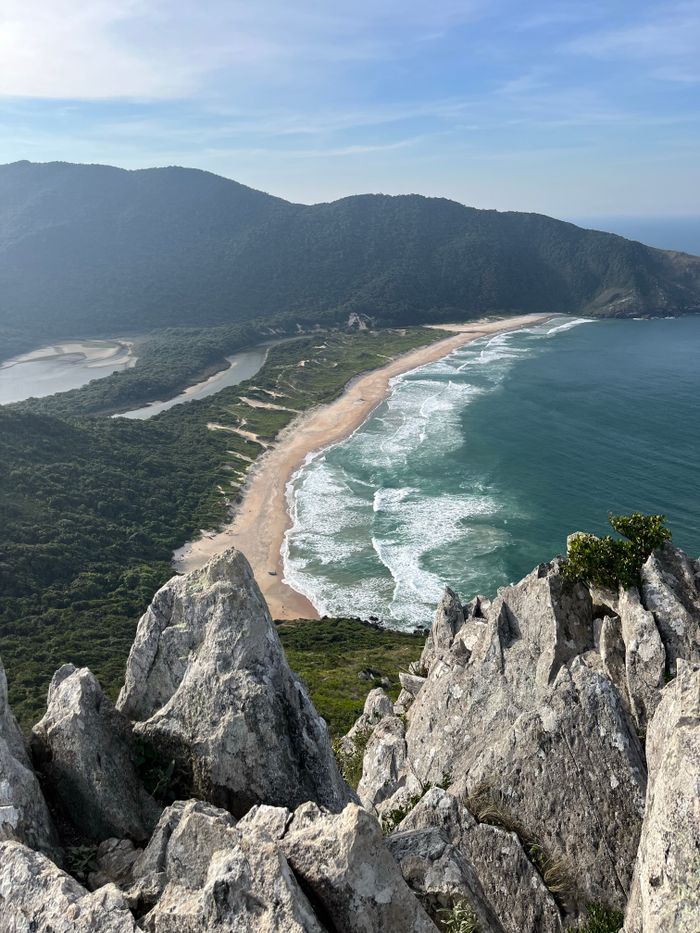 A breathtaking aerial view of Praia do Matadeiro in Florianópolis, Brazil with waves crashing along the coast.