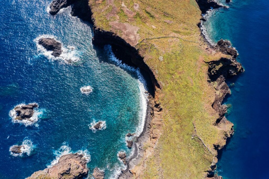 pexels-photo-34740506-34740506 Breathtaking aerial view of Madeira's coastline with rocky formations and blue ocean.