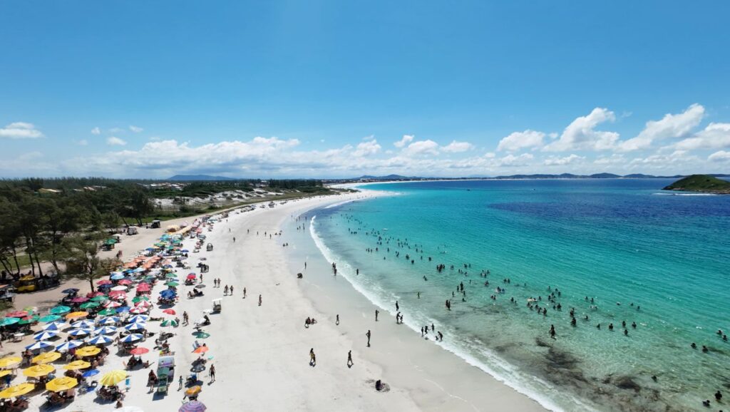 A stunning aerial view of a vibrant Brazilian beach filled with colorful umbrellas and bathers.